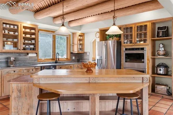 a kitchen with a table chairs refrigerator and cabinets