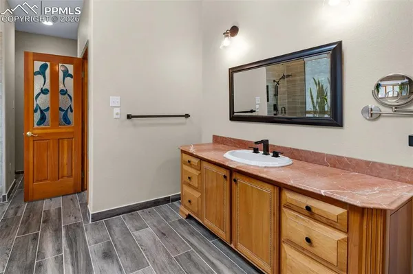 a bathroom with a granite countertop sink and a mirror