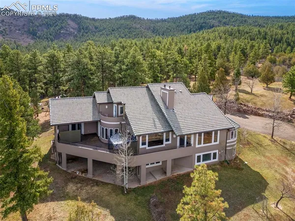 a aerial view of a house with a big yard and large trees