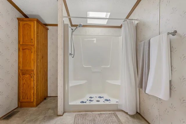 a bathroom with a shower and a glass door