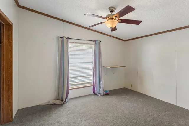an empty room with closet and a ceiling fan