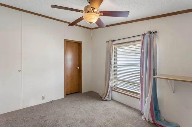 a view of a room with a ceiling fan and a window