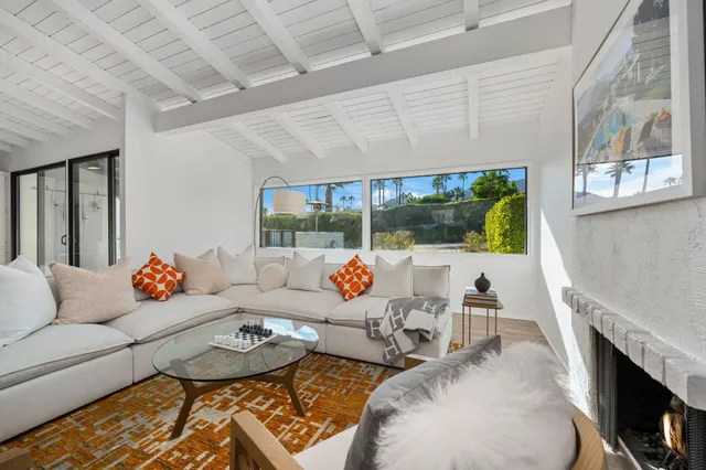 a living room with furniture and a floor to ceiling window