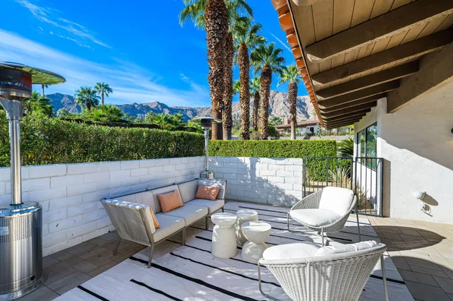 a view of a patio with couches table and chairs and potted plants