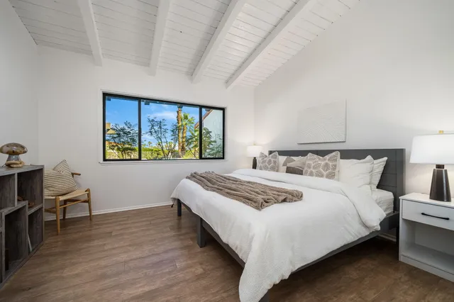 a bedroom with bed and wooden floor