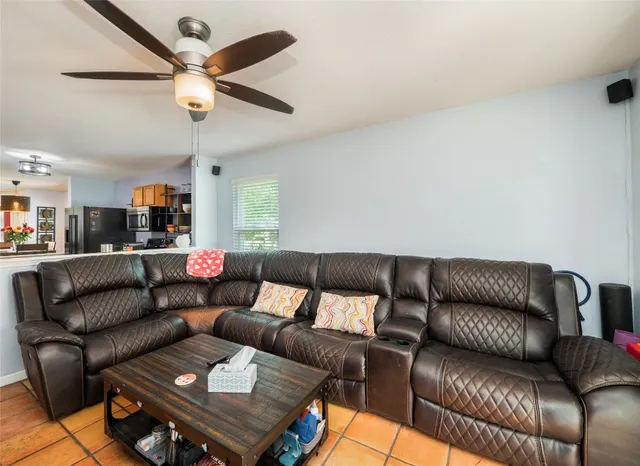 a living room with furniture and a ceiling fan