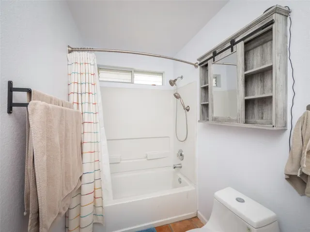 a bathroom with a shower a bath tub and a shower curtain
