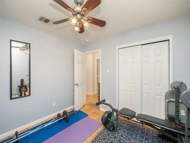 a room with gym equipment and wooden floor