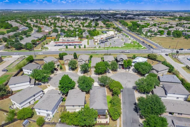 an aerial view of a city with lots of residential buildings and mountain view in back