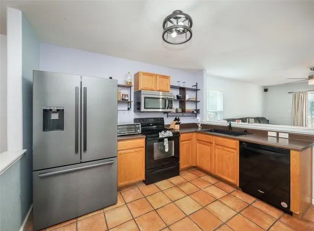 a kitchen with stainless steel appliances granite countertop a refrigerator stove and sink
