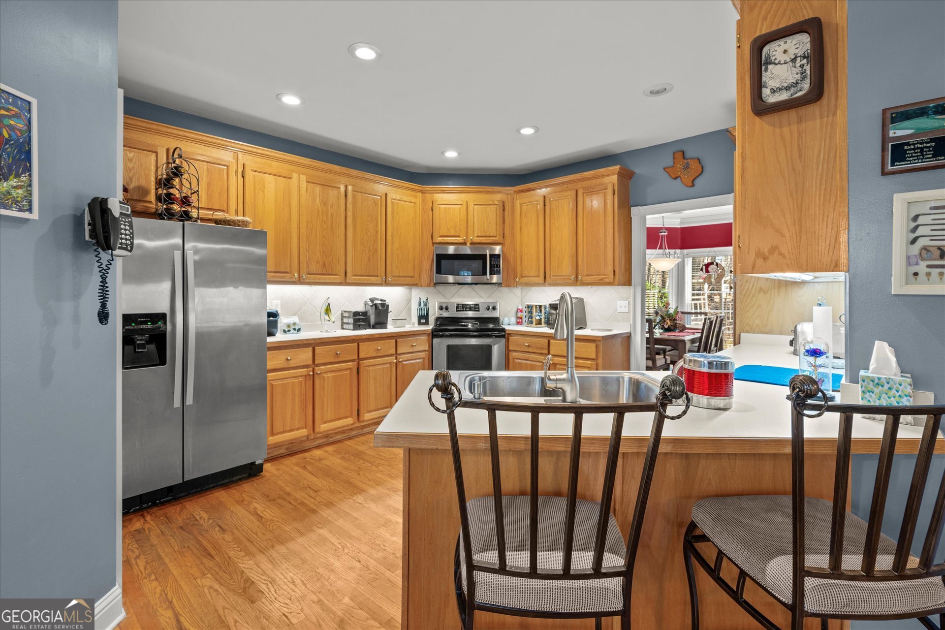 4051 Golfview Court Villa Rica, GA 30180 - Photo 14 of 77 a kitchen with stainless steel appliances granite countertop a refrigerator a stove a sink a dining table and chairs with wooden floor