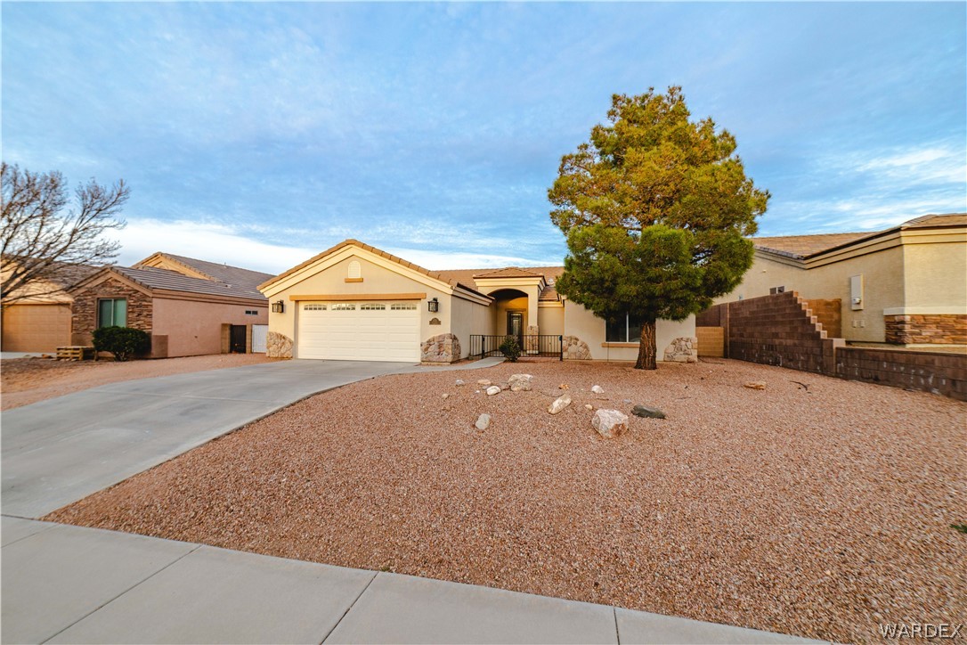 3374 Roma Road Kingman, AZ 86401 - Photo 21 of 64 View of front of home with stucco siding, driveway, a garage, and stone siding
