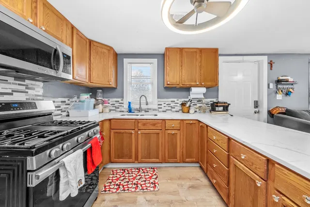 a kitchen with stainless steel appliances a stove a sink and a microwave