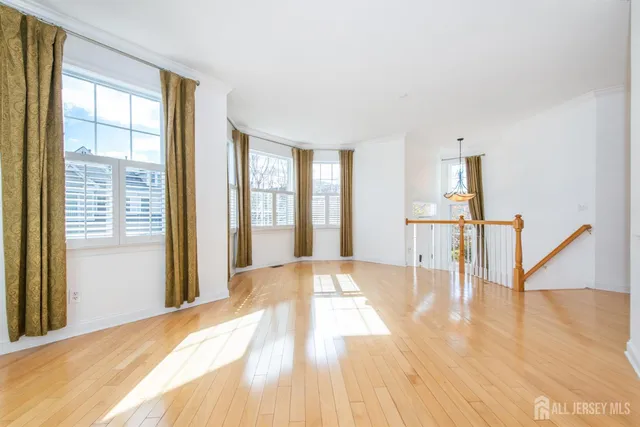 a view of a big room with windows and chandelier fan