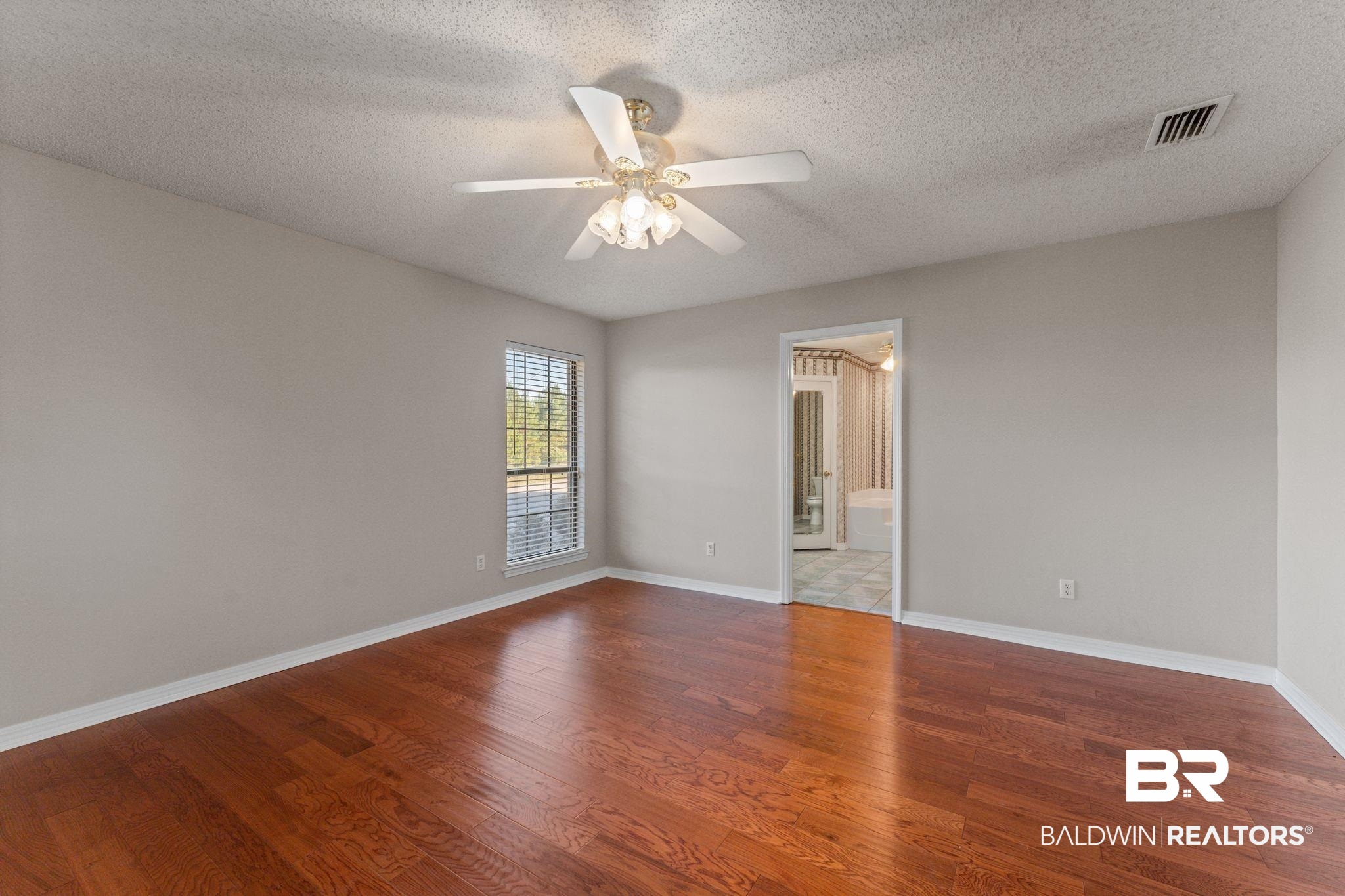 888 Mobile Cut-Off Road St. Stephens, AL 36569 - Photo 22 of 54 Empty room with a textured ceiling, wood finished floors, and a ceiling fan