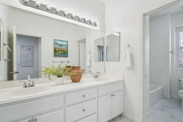 a bedroom with a bed and a table with potted plants