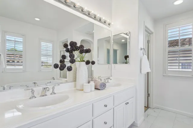 a patio with a table and chairs and potted plants