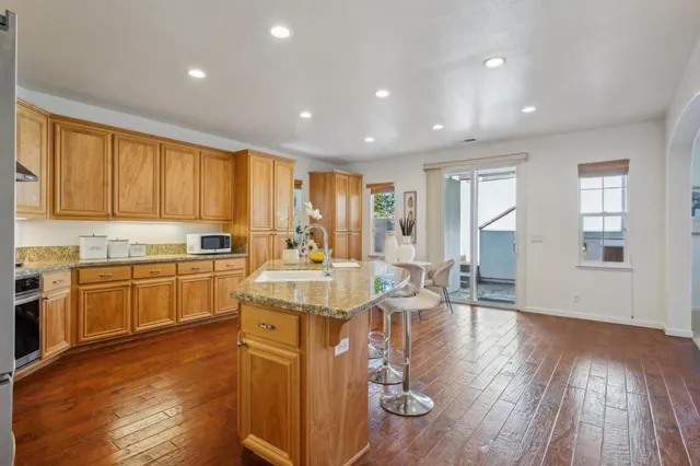 a kitchen with granite countertop stainless steel appliances white cabinets and a sink