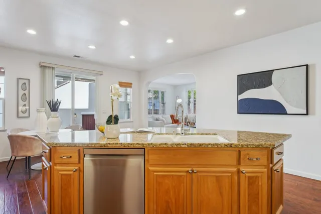 a kitchen with stainless steel appliances granite countertop a stove top oven a sink and dishwasher