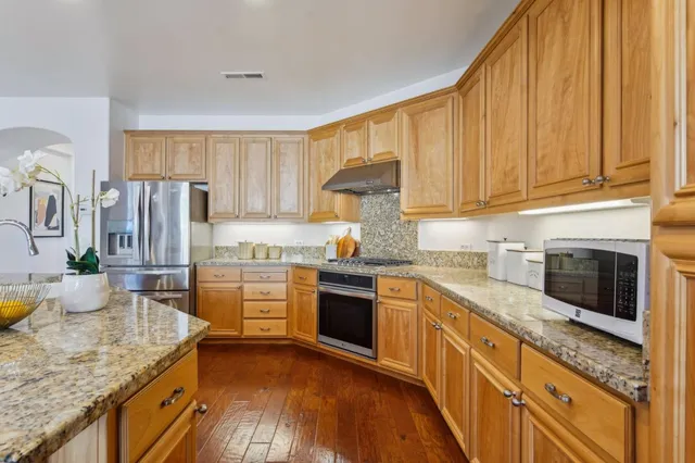 a kitchen with stainless steel appliances granite countertop a sink and cabinets