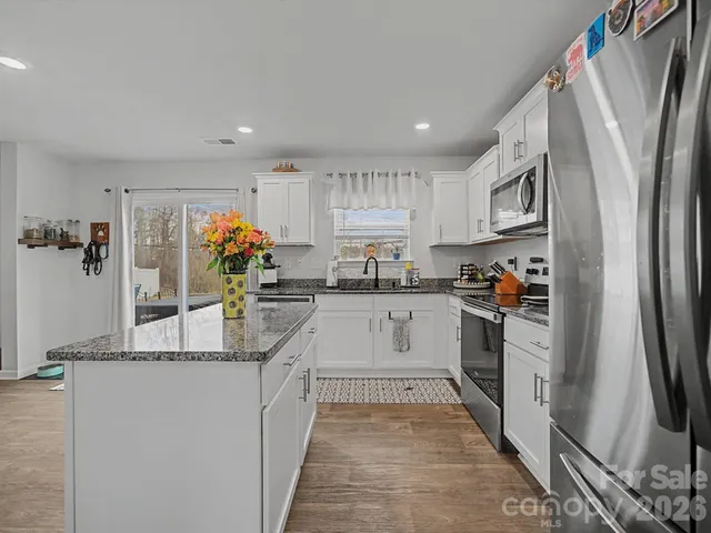 a kitchen with stainless steel appliances granite countertop a refrigerator and a sink