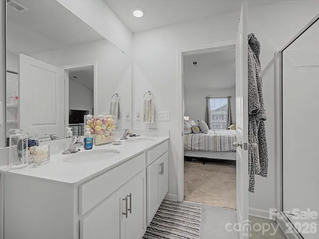 a en suite bathroom with double vanity and a mirror