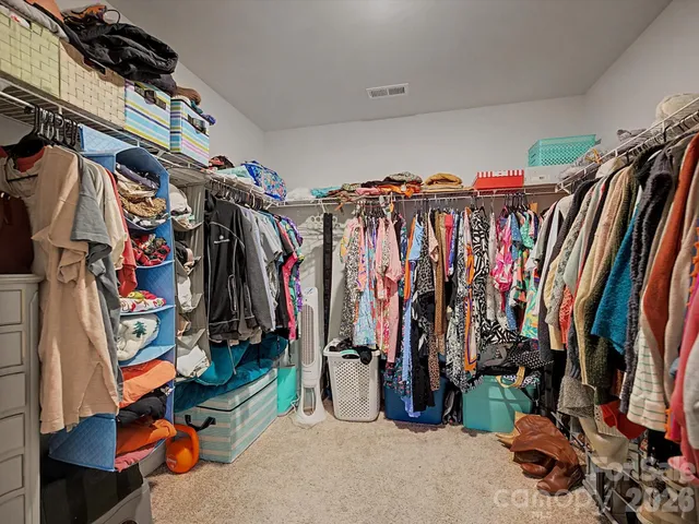a view of walk in closet with clothes