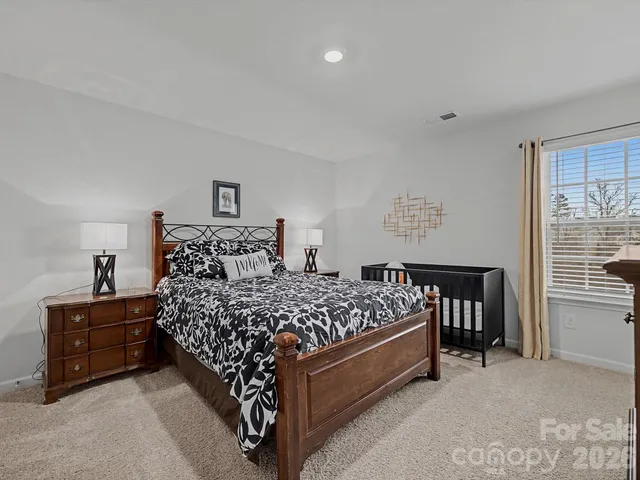 a bed sitting in a bedroom next to a window