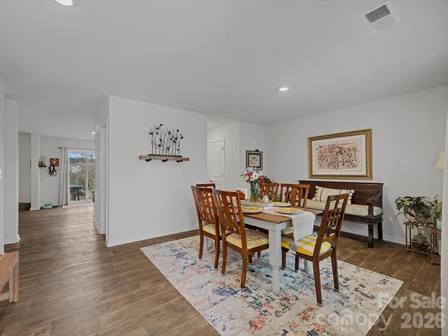 a dining room with furniture wooden floor a rug and a painting