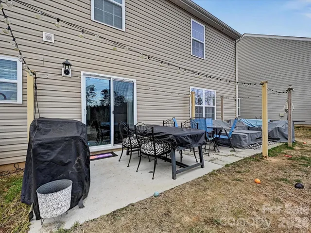 a view of a patio with dining table and chairs and plants