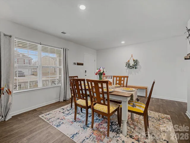 a dining room with furniture a rug and wooden floor