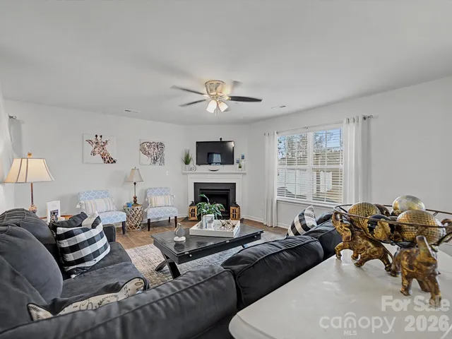 a living room with furniture a fireplace and a chandelier