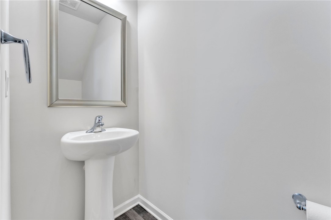 208 Samuel Street Pendleton, SC 29670 - Photo 11 of 32 A pristine powder room offers a sleek pedestal sink and contemporary mirror.