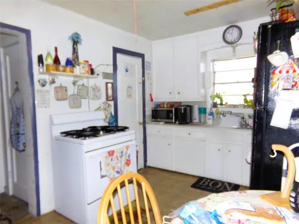 a kitchen with a stove a refrigerator a sink a counter space and a window