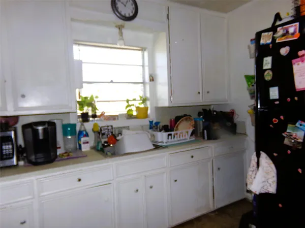 a kitchen with a white cabinets and window