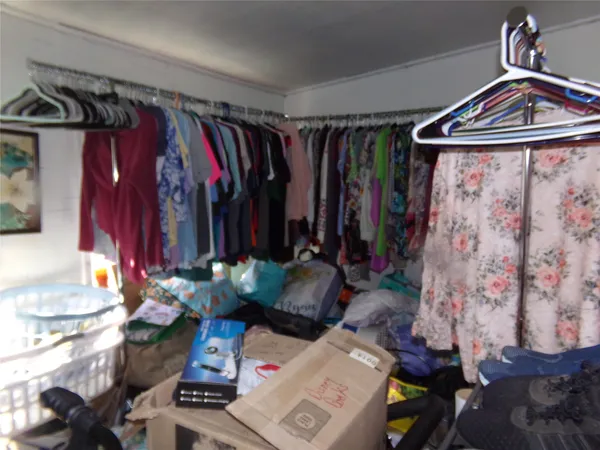 a view of walk in closet with clothes and shoes