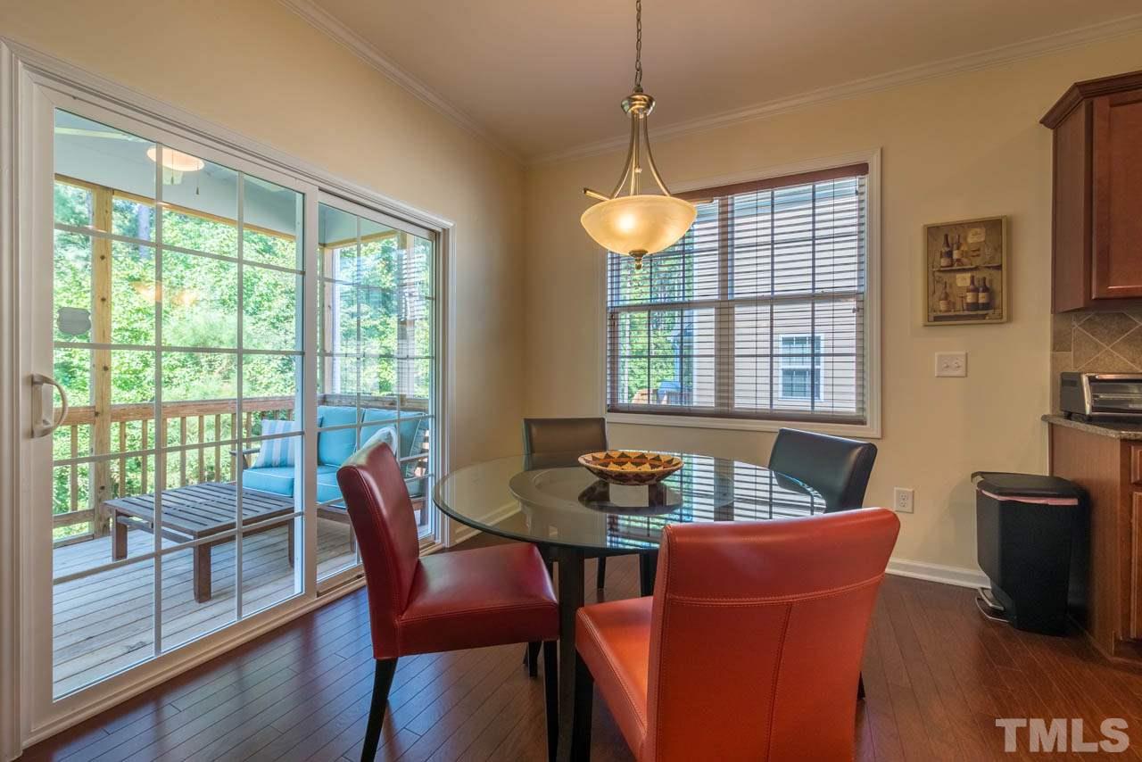 227 Strolling Way Durham, NC 27707 - Photo 11 of 25 a dining room with furniture a chandelier and wooden floor