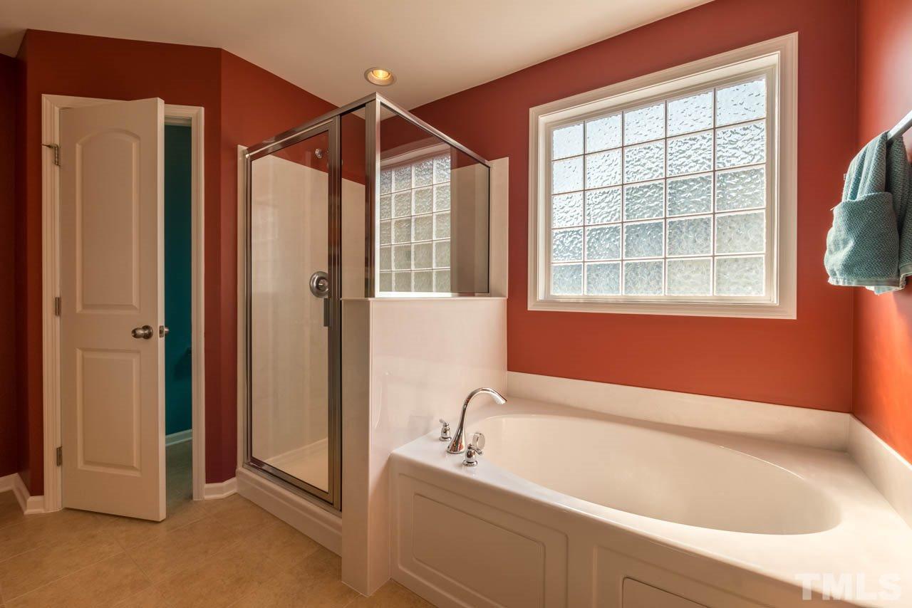 227 Strolling Way Durham, NC 27707 - Photo 16 of 25 a bathroom with a bathtub and a shower