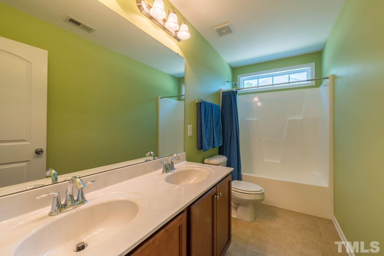 227 Strolling Way Durham, NC 27707 - Photo 19 of 25 a bathroom with a double vanity sink toilet and shower
