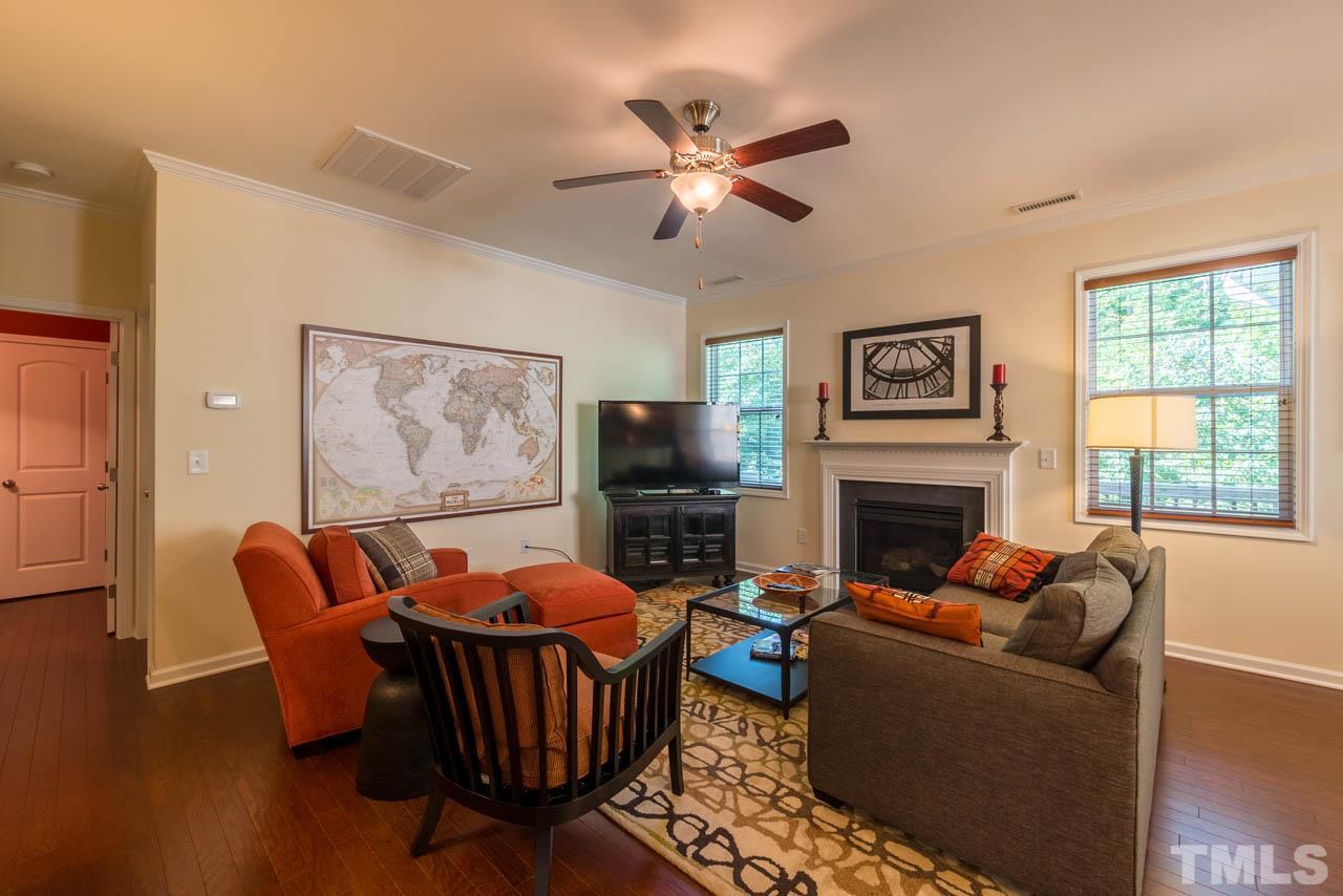 227 Strolling Way Durham, NC 27707 - Photo 5 of 25 a living room with furniture a flat screen tv and a fireplace