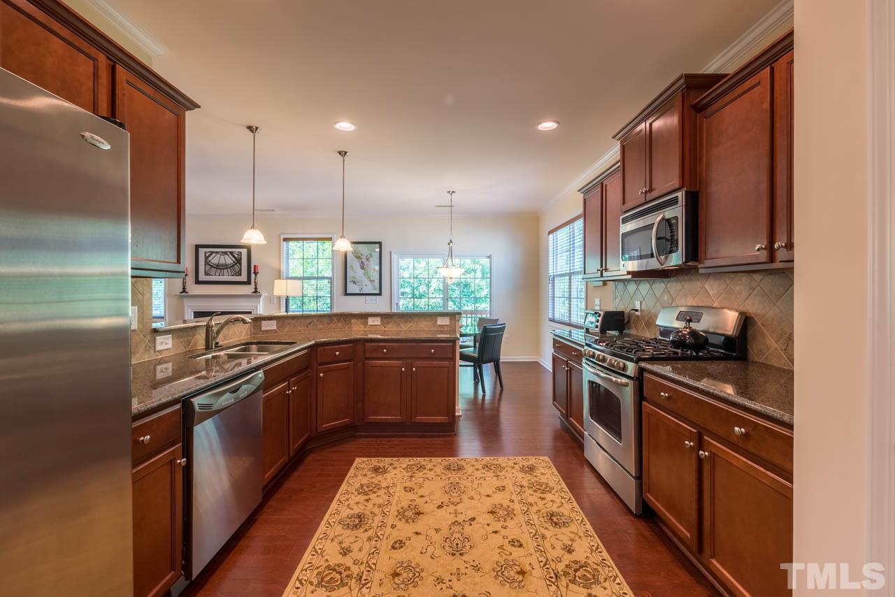 227 Strolling Way Durham, NC 27707 - Photo 7 of 25 a kitchen with stainless steel appliances granite countertop a stove a sink and a refrigerator