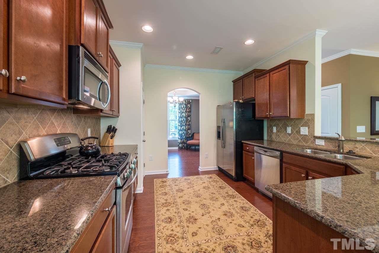 227 Strolling Way Durham, NC 27707 - Photo 8 of 25 a kitchen with stainless steel appliances granite countertop a stove sink and cabinets