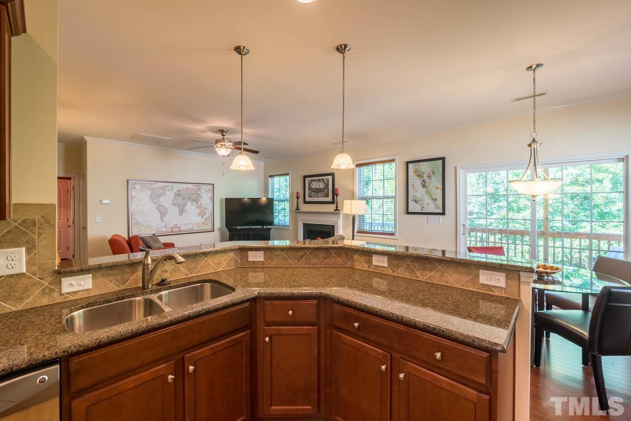 227 Strolling Way Durham, NC 27707 - Photo 10 of 25 a kitchen with a sink a counter and chairs