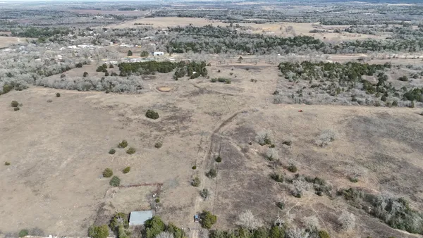 a view of a dry yard with trees