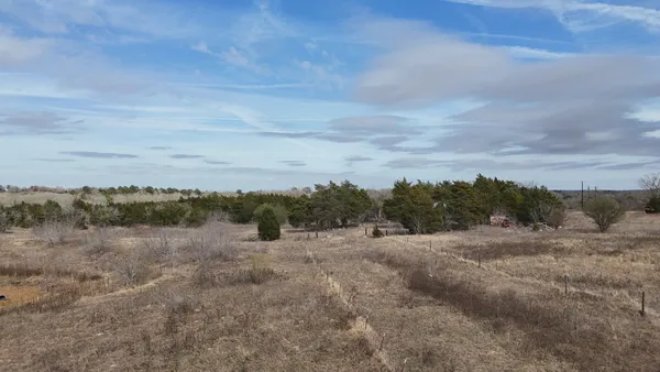 a view of a field with trees in background