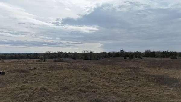 a view of dirt field and trees