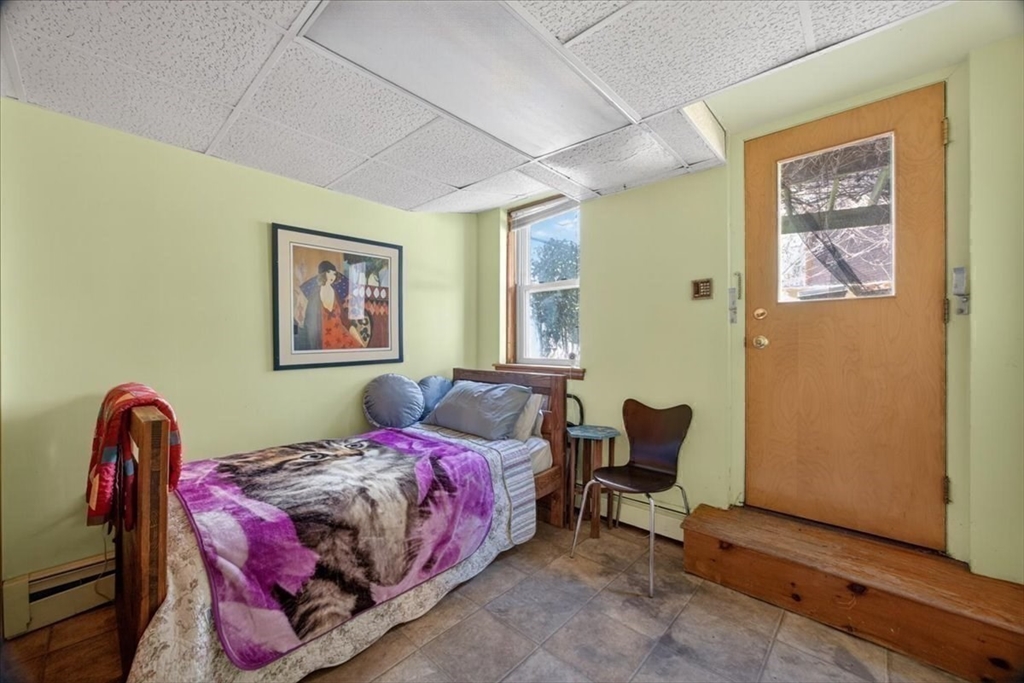 23 Netherlands Road, Unit 1 Brookline, MA 02445 - Photo 28 of 35 a bedroom with a bed and a chair
