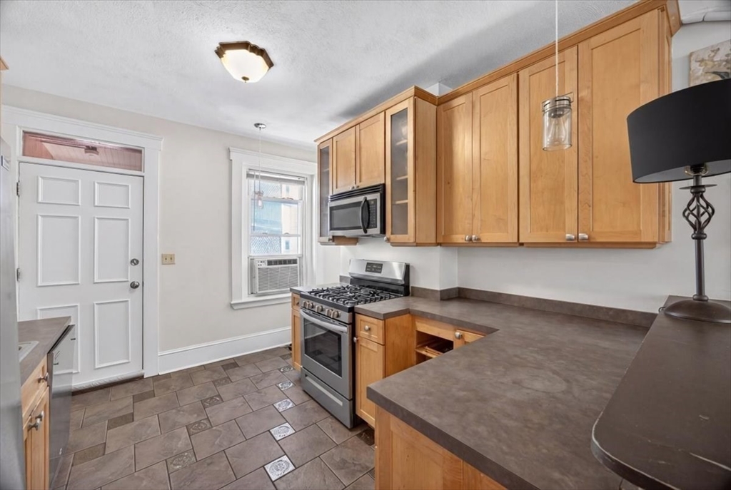23 Netherlands Road, Unit 1 Brookline, MA 02445 - Photo 3 of 35 a kitchen with stainless steel appliances granite countertop a stove a sink and a microwave