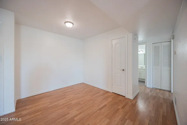 a view of empty room with wooden floor and entryway