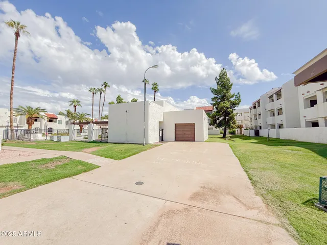 a front view of a house with garden and trees